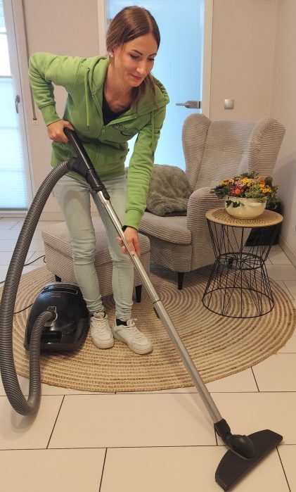 Eine Mitarbeiterin der Firma Gloger Hausdienste saugt Staub in einer Wohnung